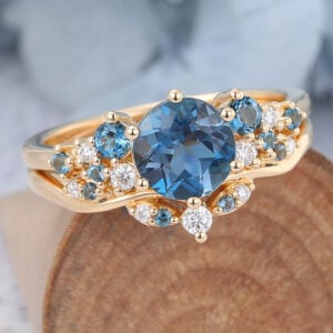 The london blue topaz bridal ring set features a topaz and moissanite cluster engagement rig and a curved wedding ring, unique and elegant. Capricorn Birthstone blue topaz meaning